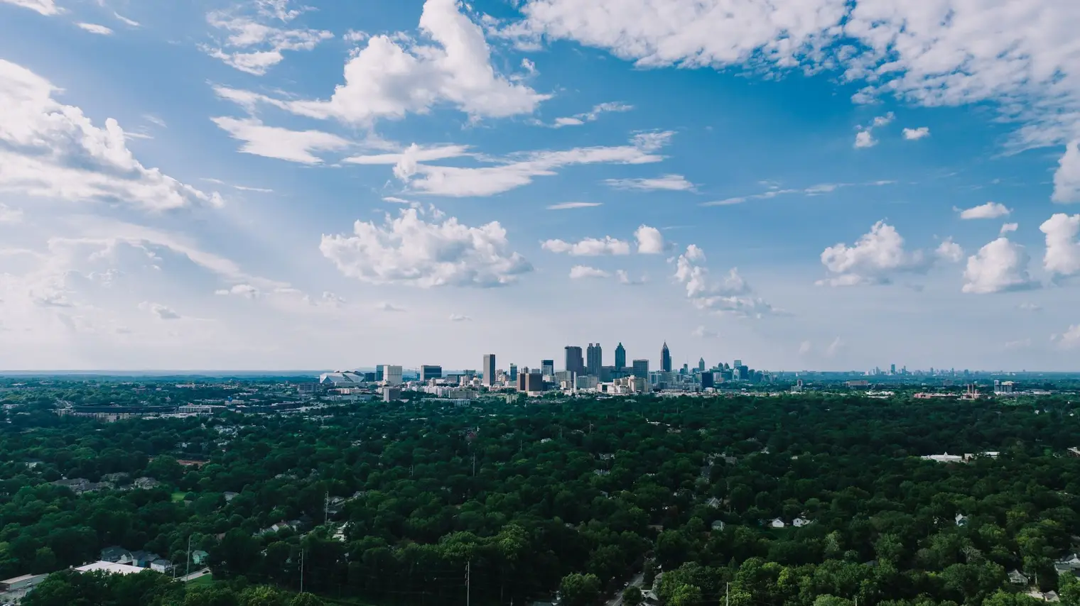 Atlanta's skyline rising above miles of green tree canopy
