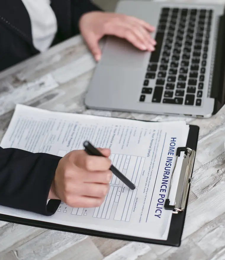 Reviewing a home insurance policy form on a clipboard