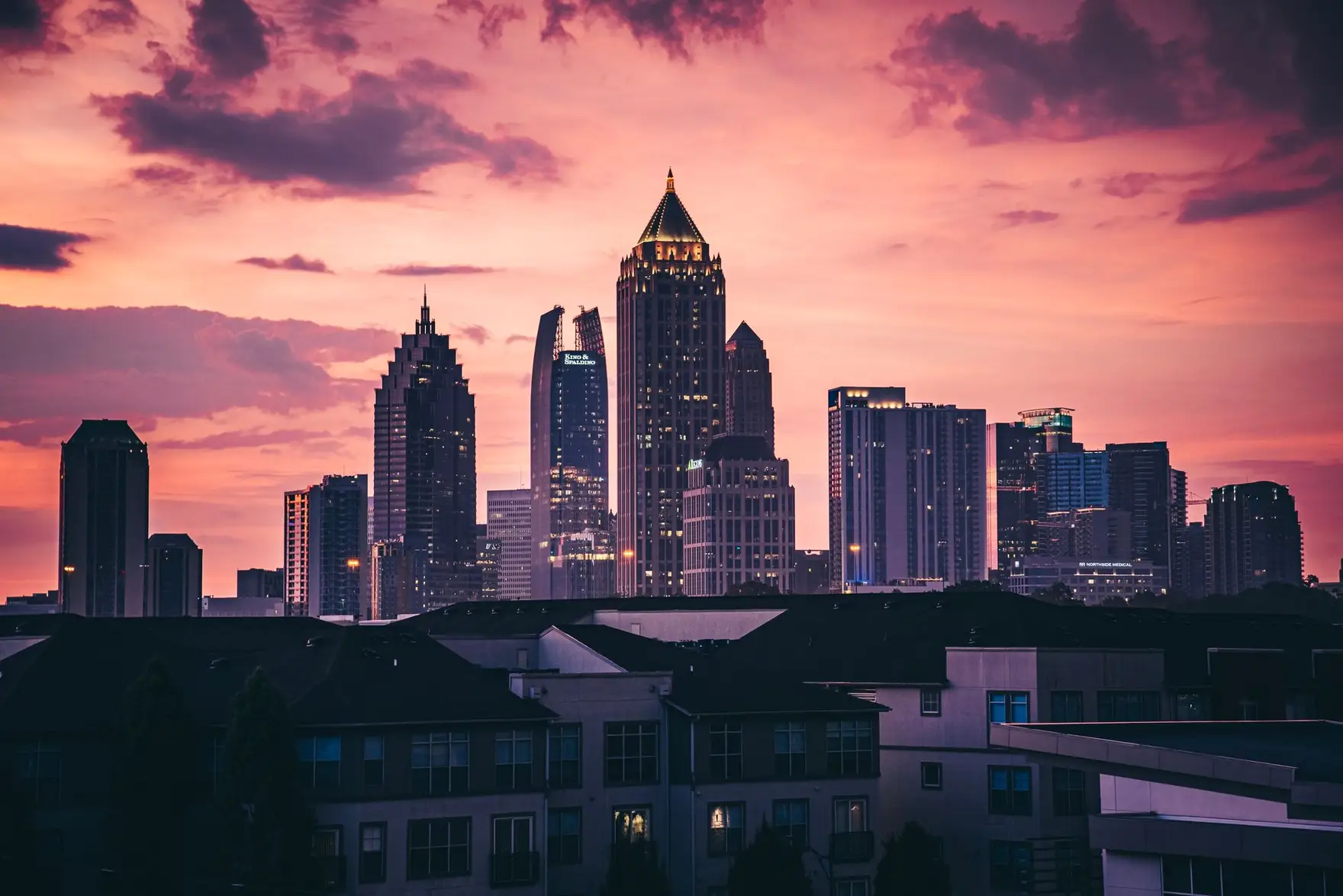 Midtown Atlanta towers at dusk under a pink evening sky